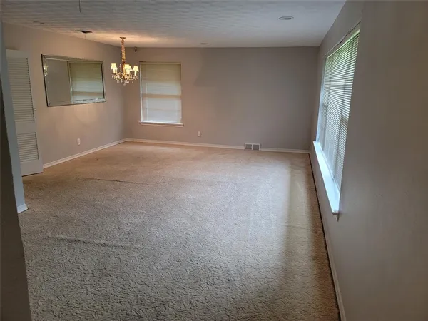 en empty room with windows and fireplace