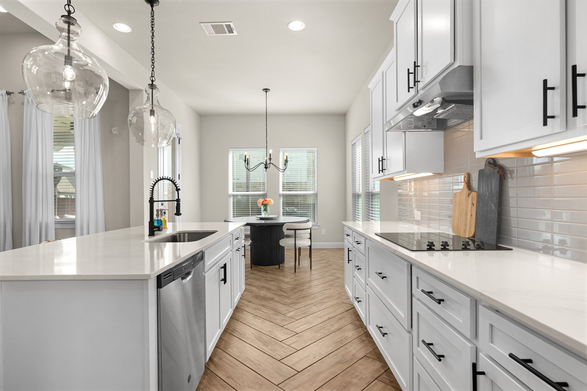 2100 Highland Ridge Road Georgetown, TX 78628 - Photo 13 of 30 A well-appointed culinary space featuring pristine white cabinetry, quartz countertops, and a striking herringbone wood floor.