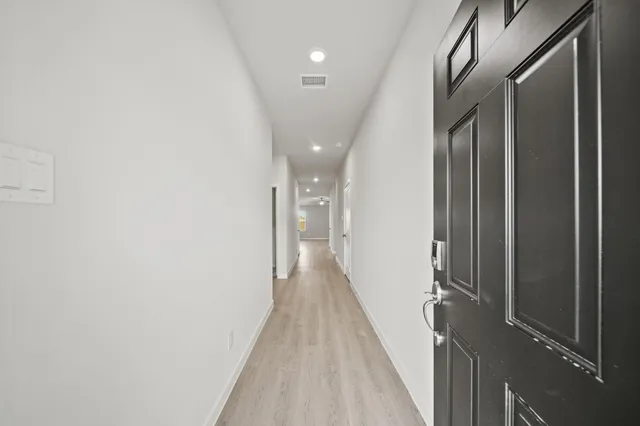 a view of a hallway with wooden floor