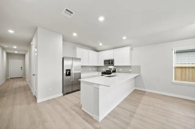 a kitchen with stainless steel appliances a sink stove and refrigerator