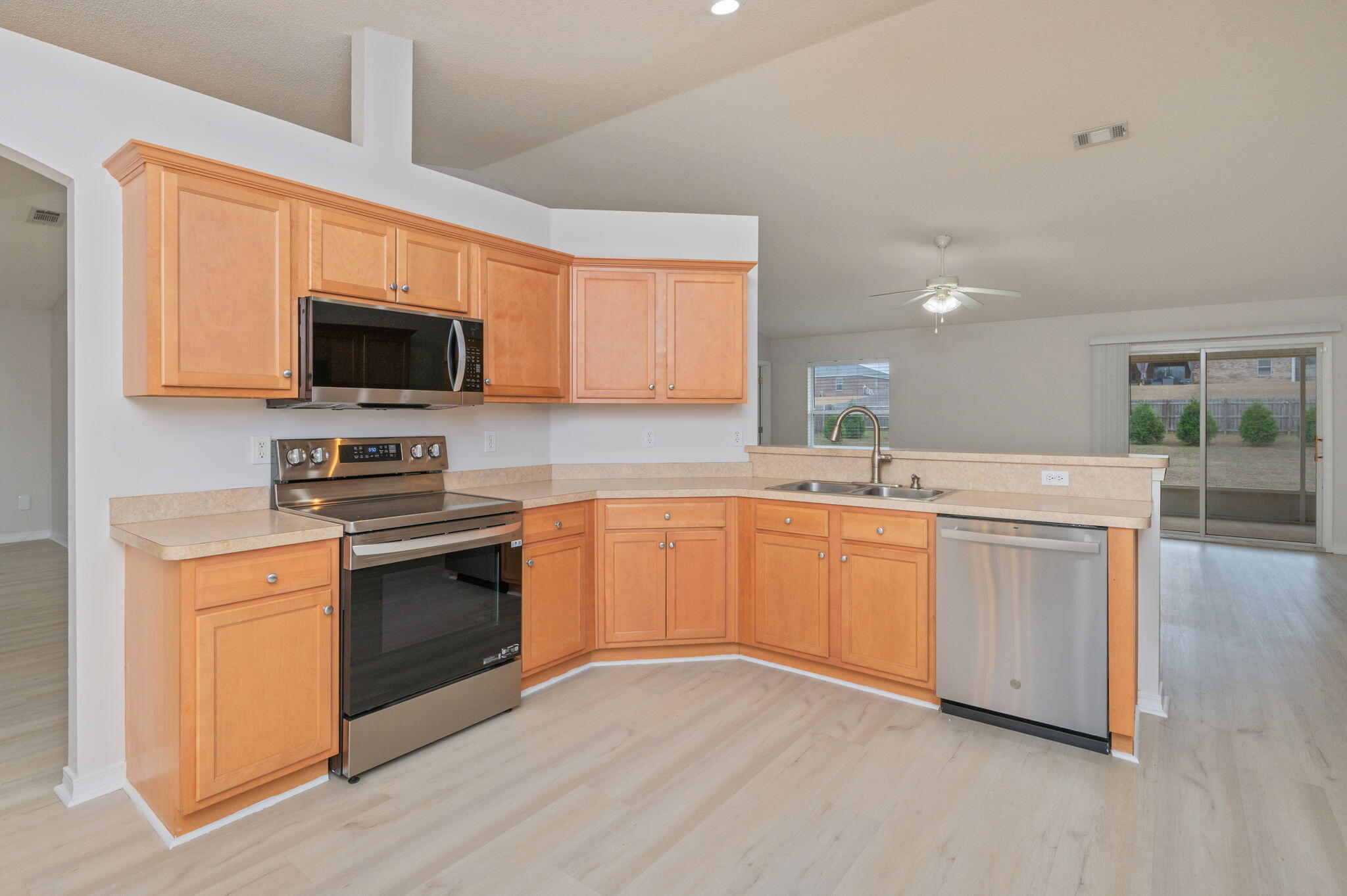 2405 Cumberland Way Crestview, FL 32536 - Photo 15 of 47 a kitchen with stainless steel appliances granite countertop a stove top oven a sink dishwasher and a microwave oven with white cabinets