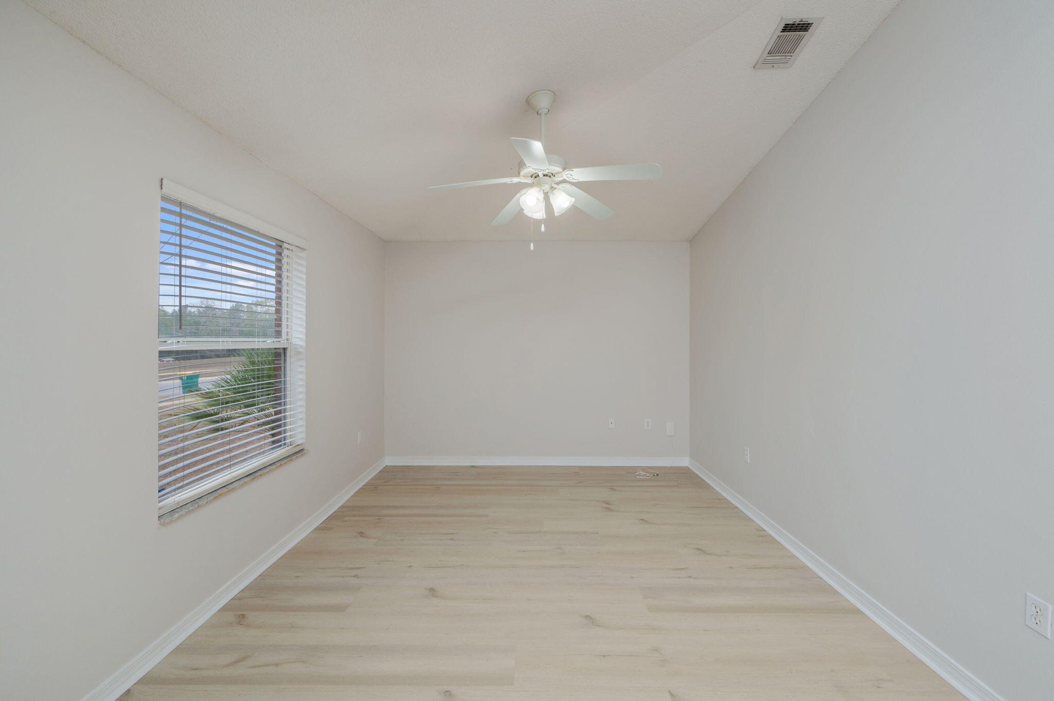 2405 Cumberland Way Crestview, FL 32536 - Photo 8 of 47 wooden floor in an empty room with a window