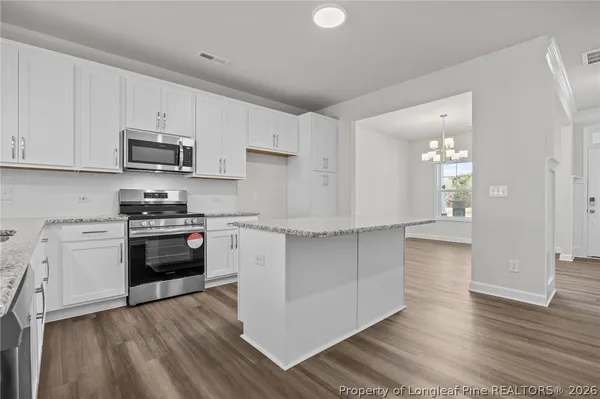 a view of a room with a wooden floor and a kitchen view