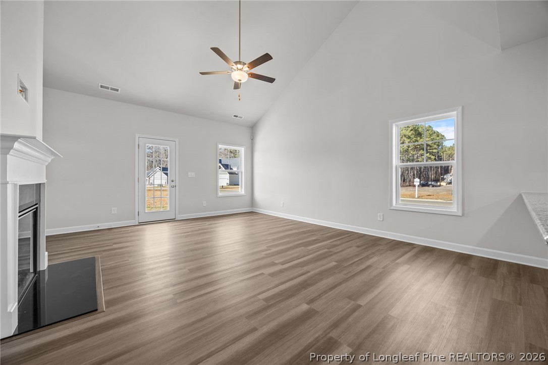 287 Elijah Way Vass, NC 28394 - Photo 23 of 49 an empty room with wooden floor chandelier and windows