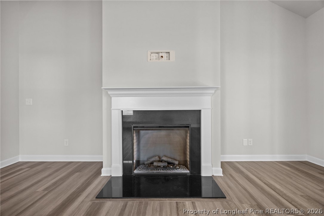 287 Elijah Way Vass, NC 28394 - Photo 24 of 49 a living room with a fireplace and wooden floor