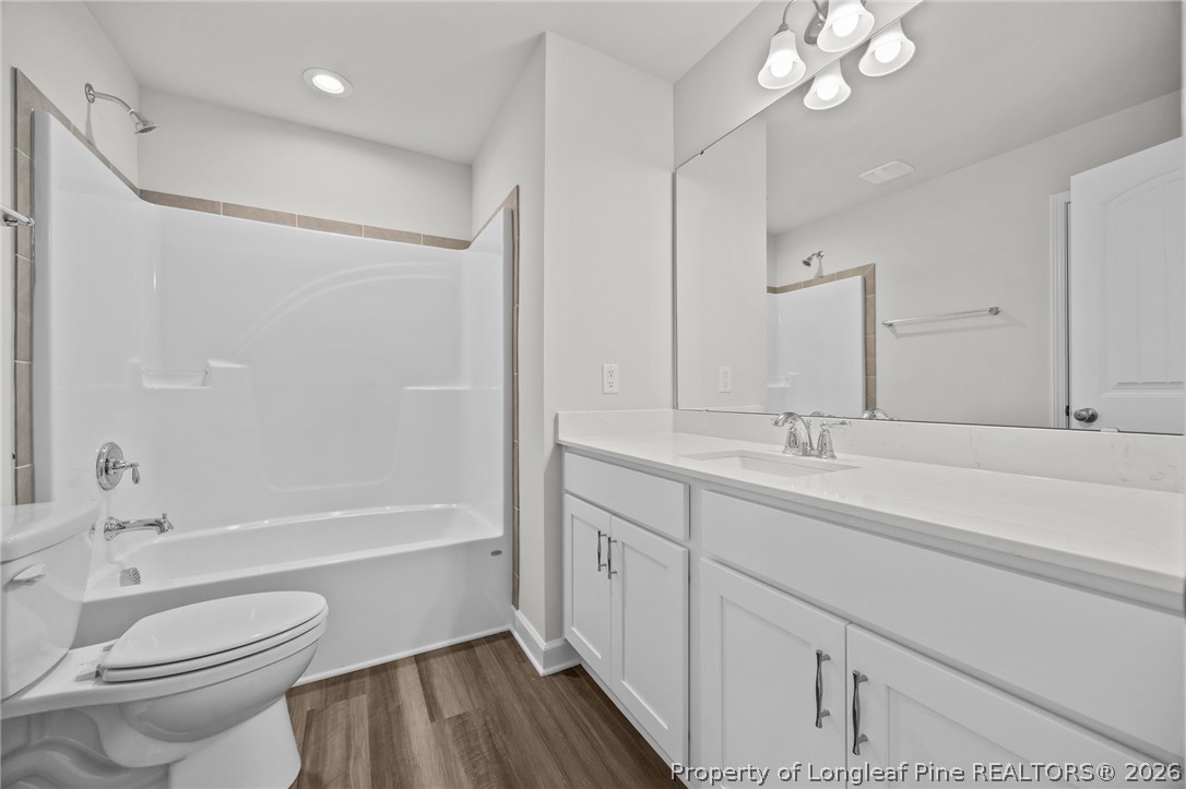 287 Elijah Way Vass, NC 28394 - Photo 38 of 49 a bathroom with a sink a toilet and a large mirror