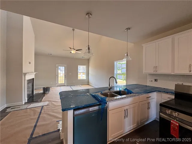a kitchen with granite countertop a sink a counter space appliances and cabinets
