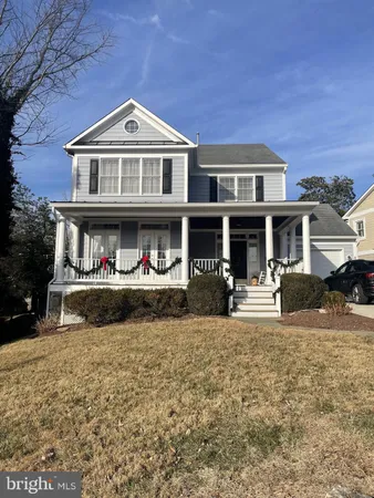a front view of a house with a yard covered in snow