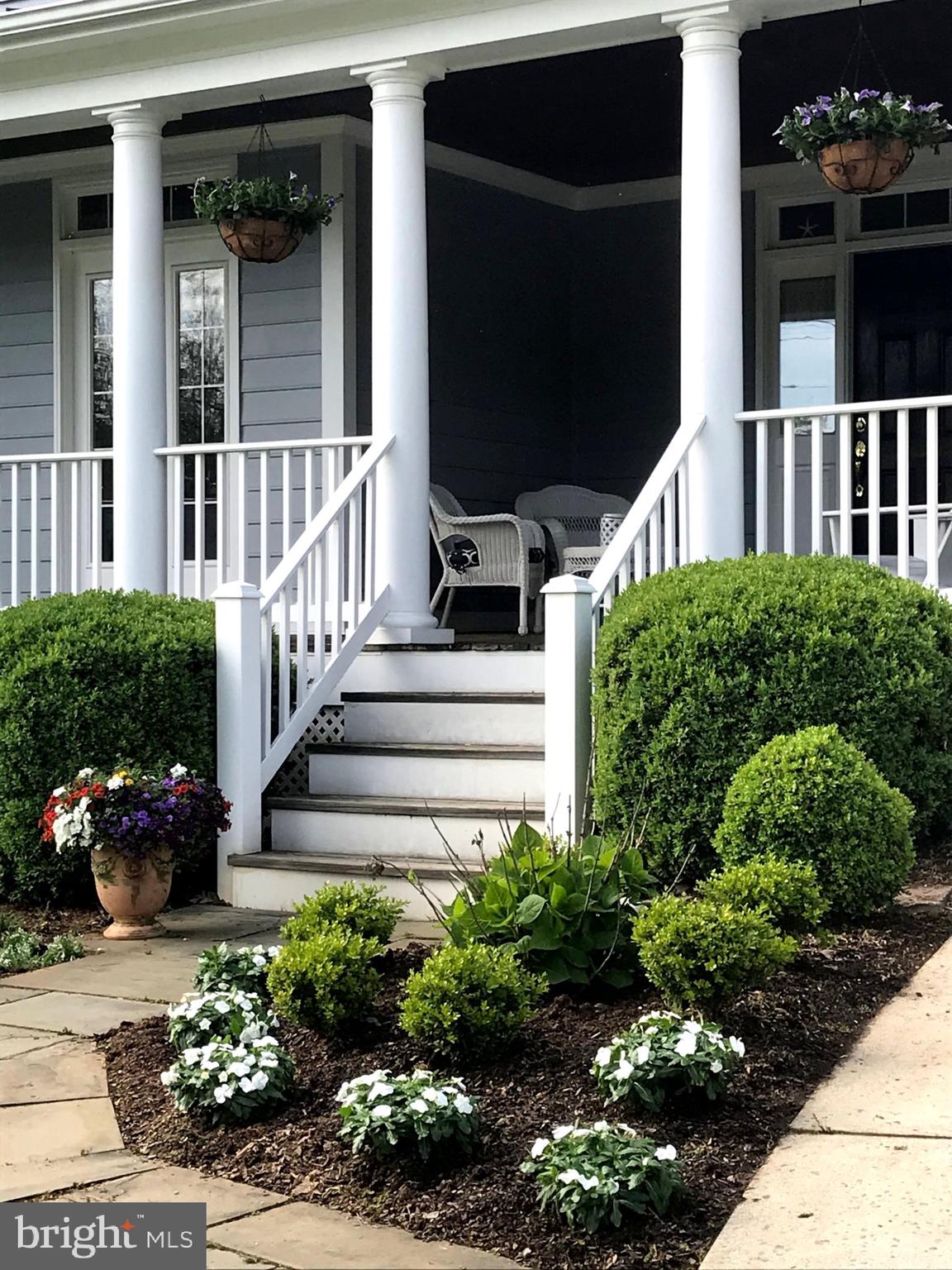 8807 Ridge Road Bethesda, MD 20817 - Photo 72 of 72 a view of a house with potted plants and a bench in front of it