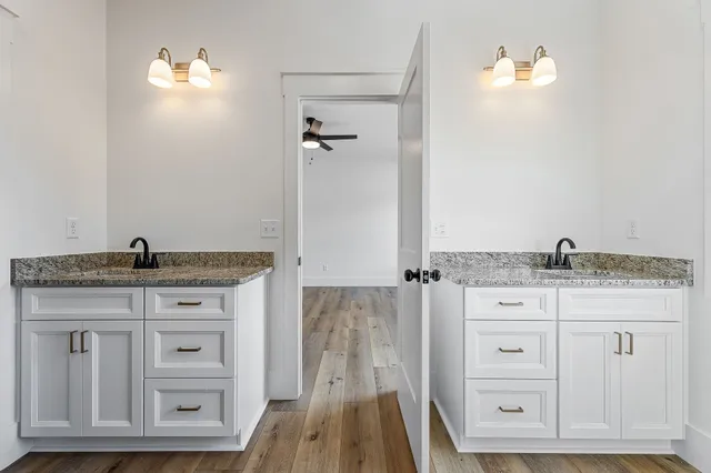 a bathroom with a granite countertop sink vanity and mirror