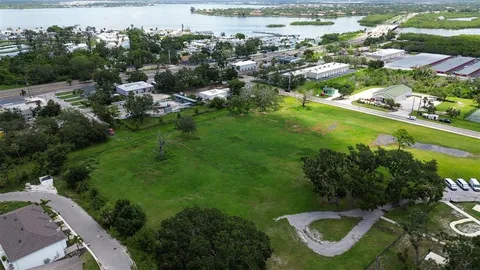 an aerial view of residential houses with outdoor space and trees