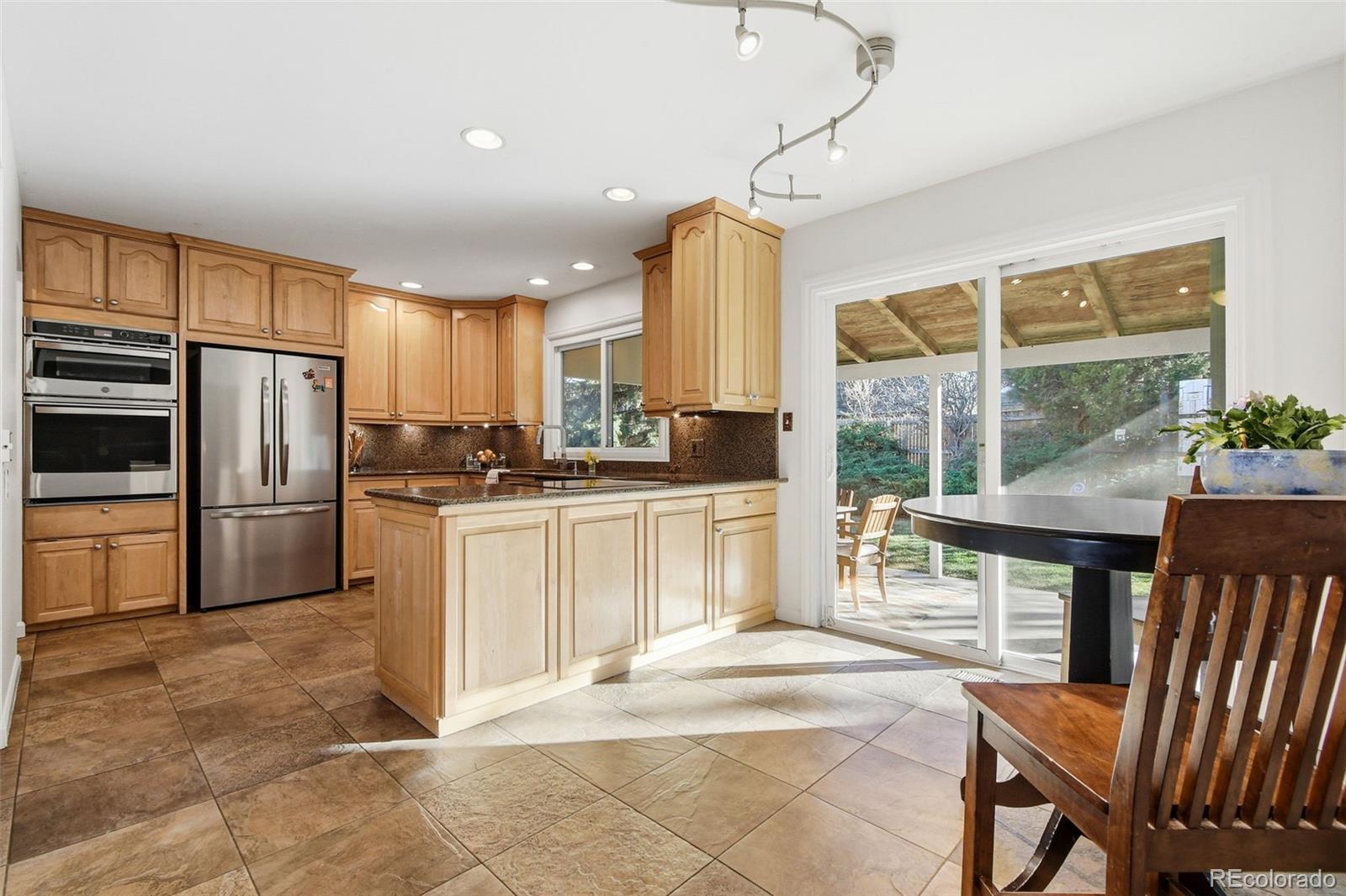 3561 South Oneida Way Denver, CO 80237 - Photo 12 of 48 a kitchen with sink cabinets and refrigerator