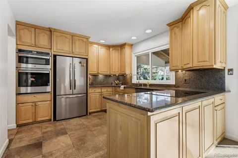 a kitchen with stainless steel appliances granite countertop a refrigerator sink and cabinets