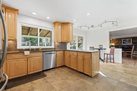 a kitchen with stainless steel appliances granite countertop sink window and cabinets