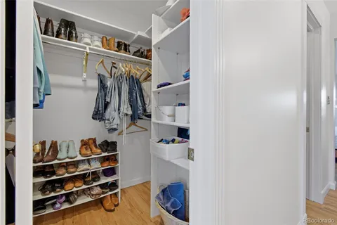 a view of walk in closet with clothes and shoes