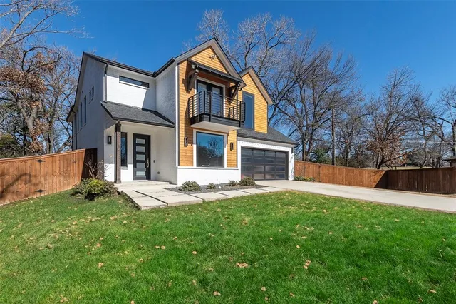 a front view of a house with a yard and trees