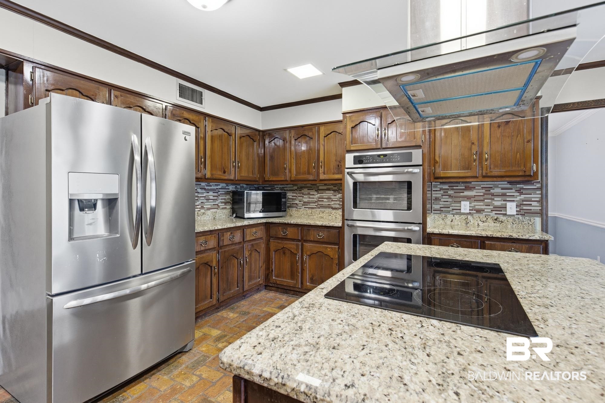 9215 Shiloh Drive Mobile, AL 36695 - Photo 8 of 32 Kitchen featuring stainless steel appliances, crown molding, ventilation hood, backsplash, and light stone countertops