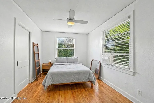 a bedroom with a bed flat screen tv and a large window