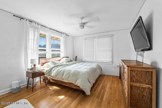 a bedroom with a bed window and flat screen tv