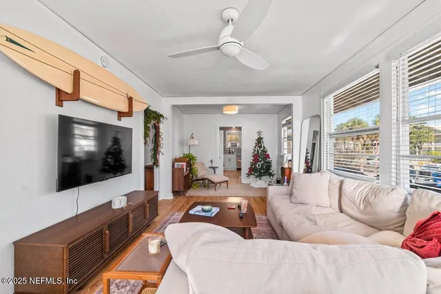 a living room with furniture a flat screen tv and a large window
