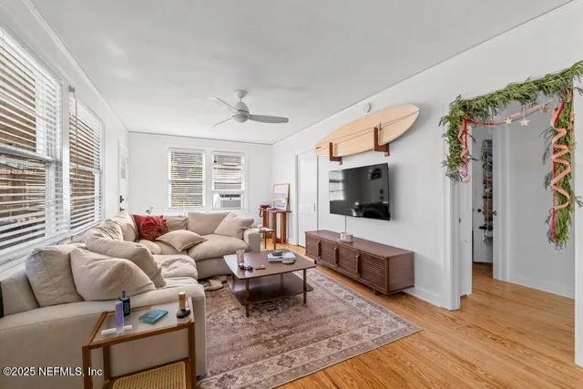 a living room with furniture flowers and a potted plant