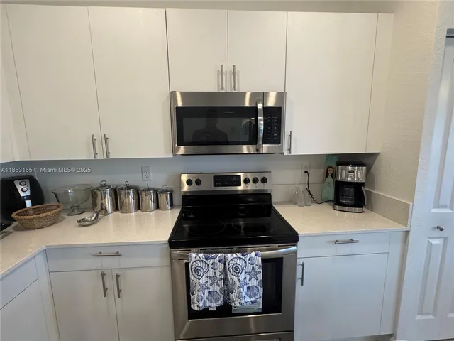a kitchen with a sink a stove and cabinets