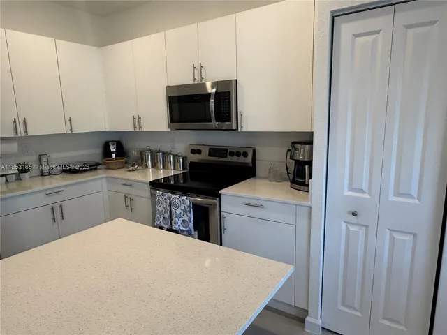 a kitchen with stainless steel appliances granite countertop a sink a stove and a microwave