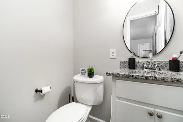 a bathroom with a toilet mirror and a sink