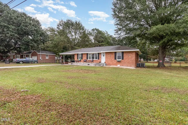 a view of a house with patio and a yard