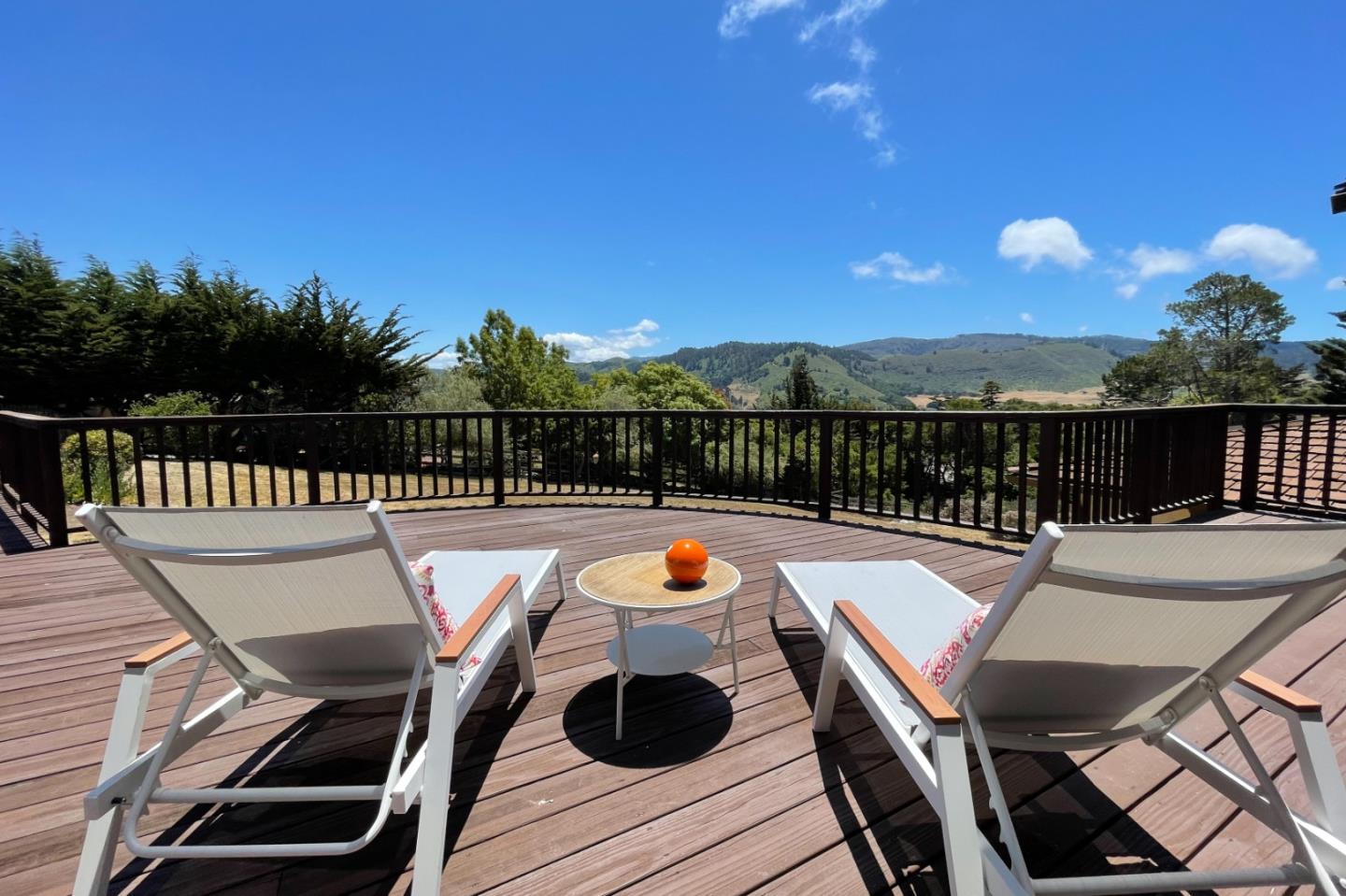 a view of a balcony with two chairs and a potted plant