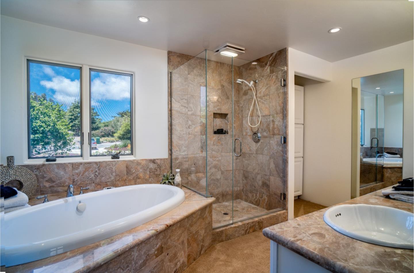 25815 Rio Vista Drive Carmel, CA 93923 - Photo 23 of 49 a bathroom with a granite countertop tub shower sink and mirror
