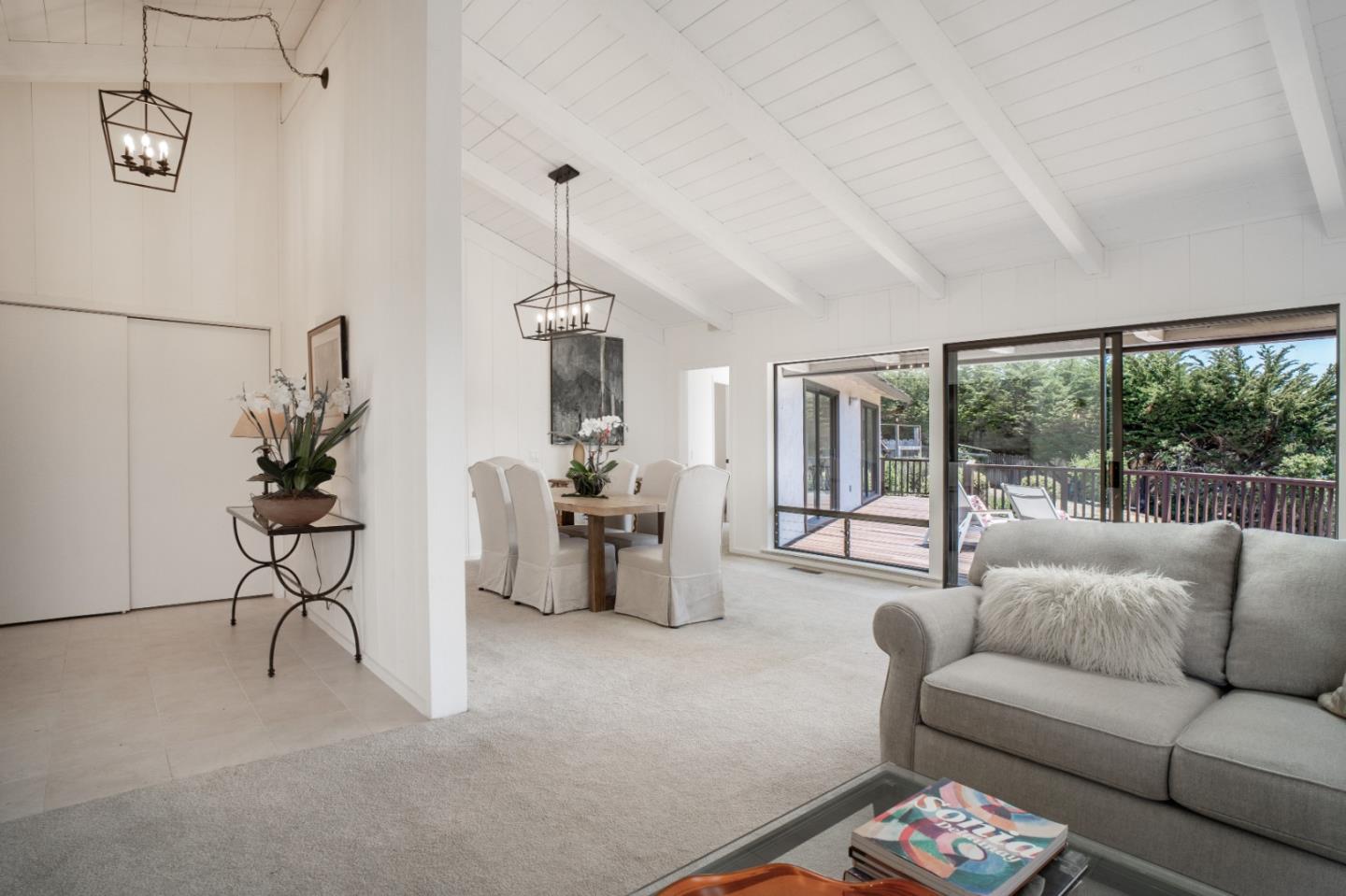 25815 Rio Vista Drive Carmel, CA 93923 - Photo 4 of 49 a living room with furniture a chandelier and a floor to ceiling window