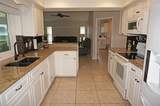 a kitchen with stainless steel appliances granite countertop a sink stove and cabinets