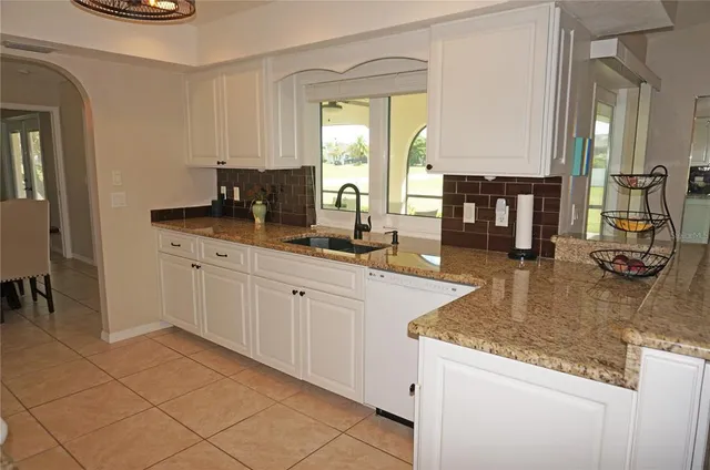 a view closed window a sink and a granite counter top