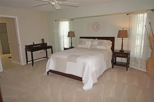 a bedroom with a bed and a flat tv screen on dresser