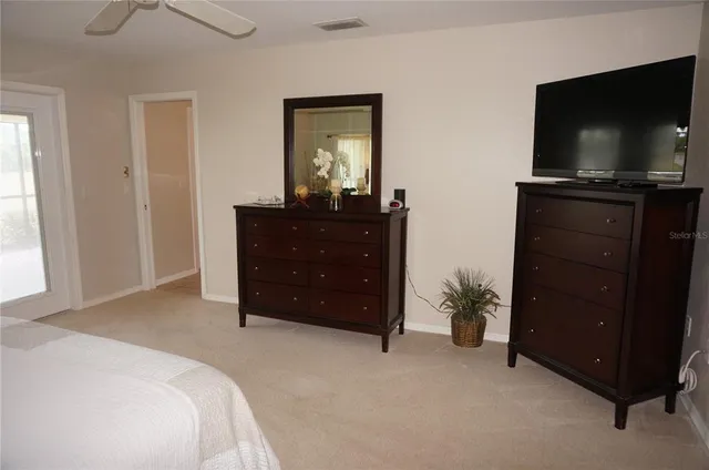 a spacious bedroom with a bed and wooden floor