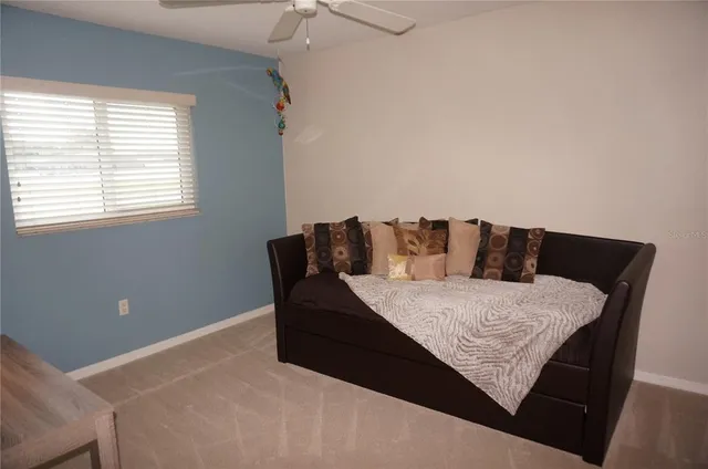 a bed sitting in a bedroom next to a window