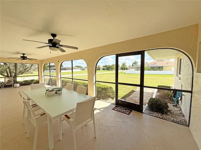 a dining room with furniture large windows and a chandelier