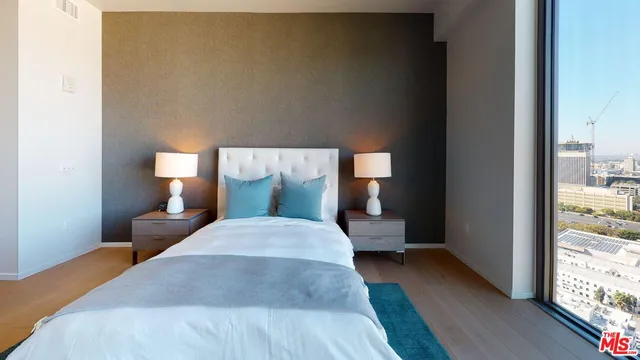 a bedroom with a bed and wooden floor