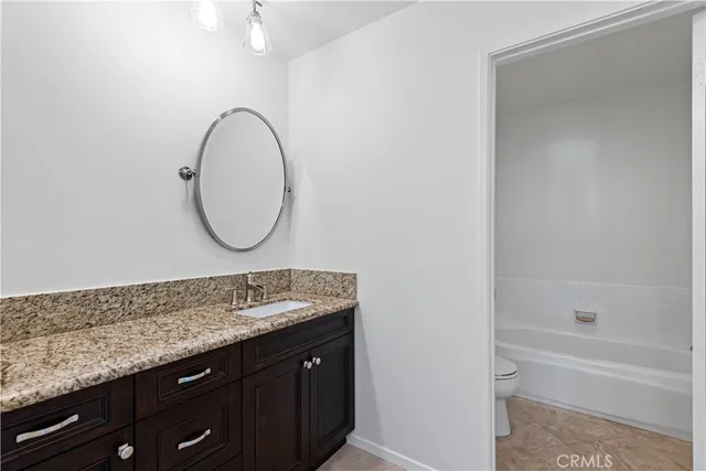 a bathroom with a granite countertop double vanity sink and a mirror
