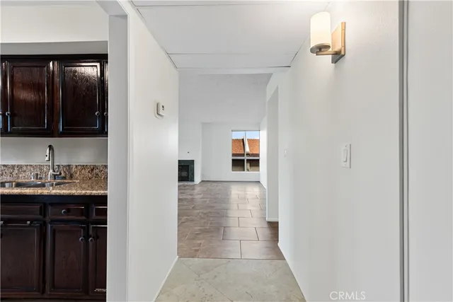 a view of a hallway with wooden floor and a bathroom