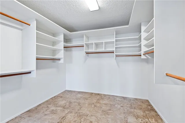 a view of walk in closet with empty racks