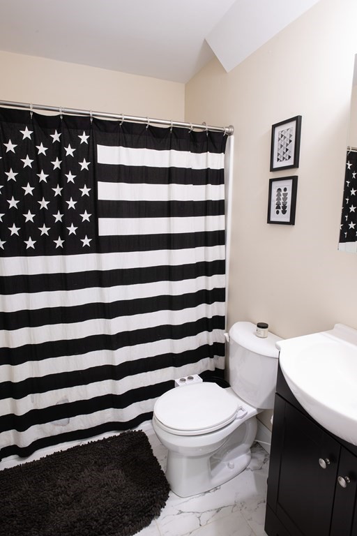 27 Fay Road, Unit 27 Framingham, MA 01702 - Photo 14 of 32 a bathroom with a toilet a sink and a mirror