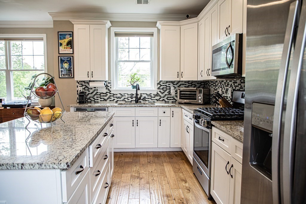 27 Fay Road, Unit 27 Framingham, MA 01702 - Photo 3 of 32 a kitchen with stainless steel appliances granite countertop a sink stove and refrigerator