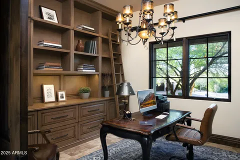 a view of a workspace with furniture and a window