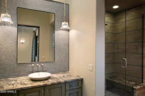 a bathroom with a granite countertop sink and a mirror