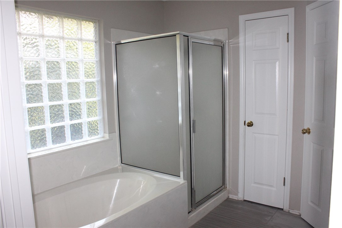 7801 Varcella Trail Austin, TX 78729 - Photo 14 of 26 a bathroom with a bathtub and a shower