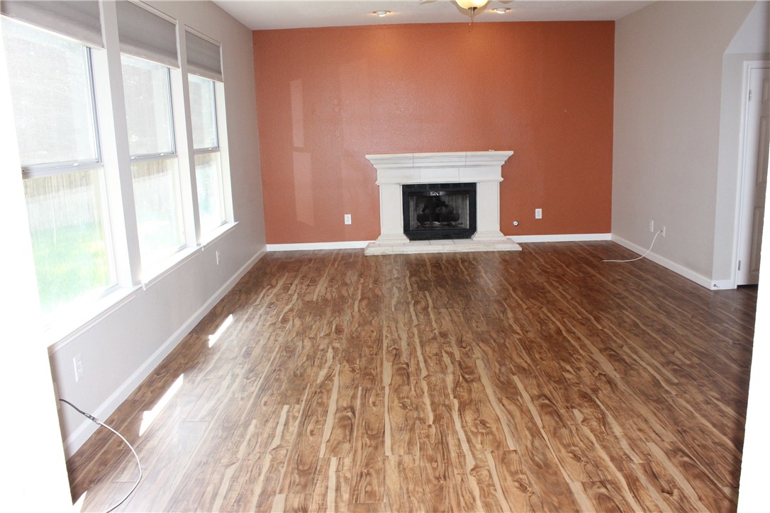 7801 Varcella Trail Austin, TX 78729 - Photo 2 of 26 a view of empty room with wooden floor and fireplace