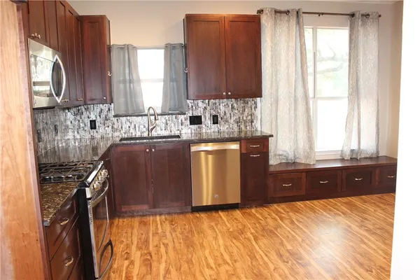 a kitchen with a stove a sink and a window