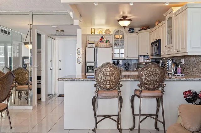 a kitchen with stainless steel appliances granite countertop a refrigerator sink and stove top oven